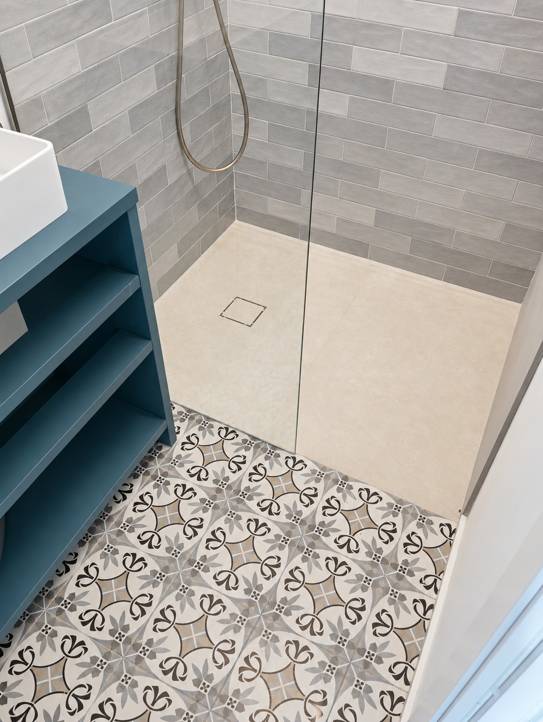 Ducha beige junto a suelo decorativo y mueble azul